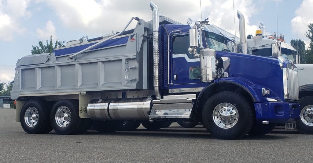 Large blue truck with gray steel trailer bed